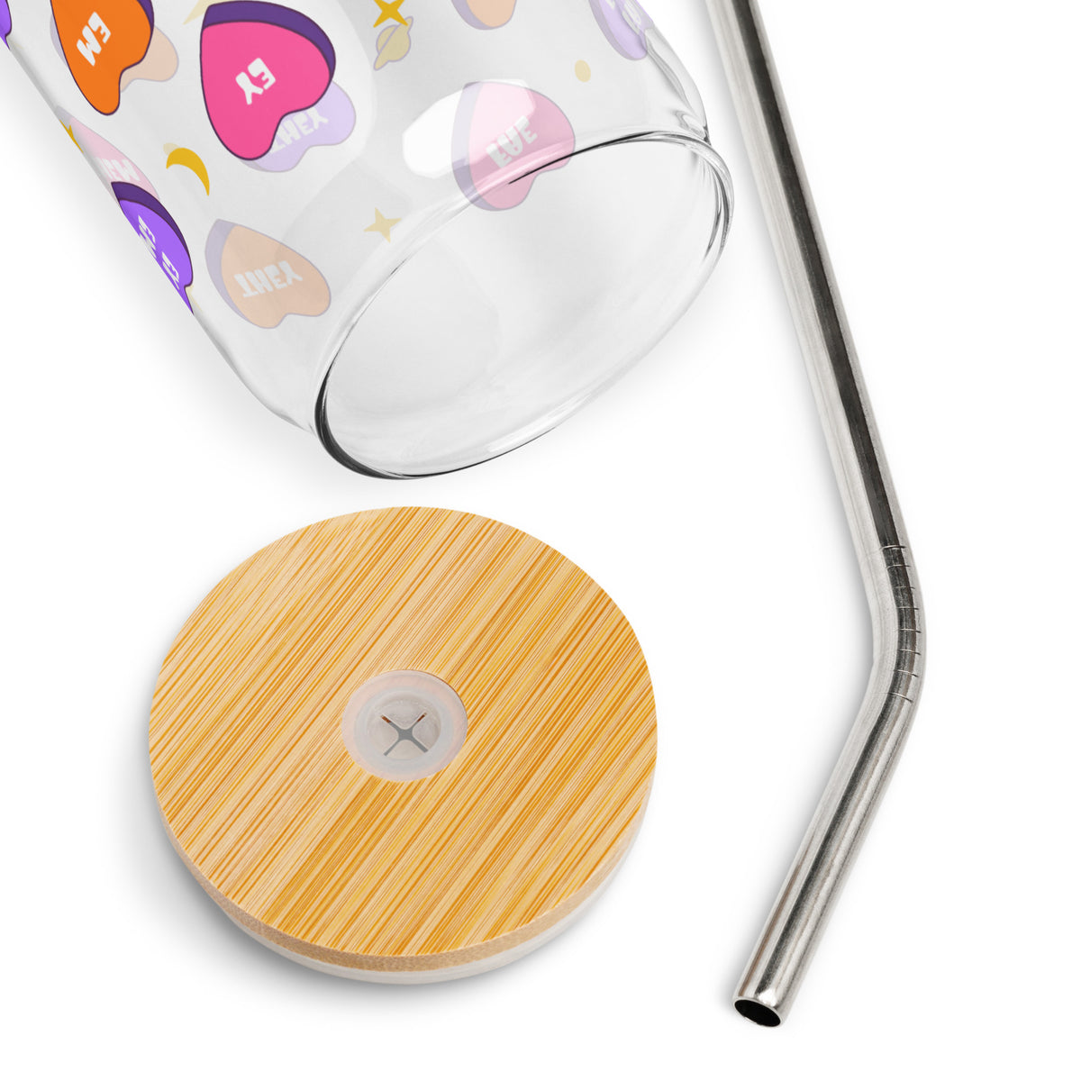 Glass tumbler with colorful designs, wooden coaster, and metal straw on a white background