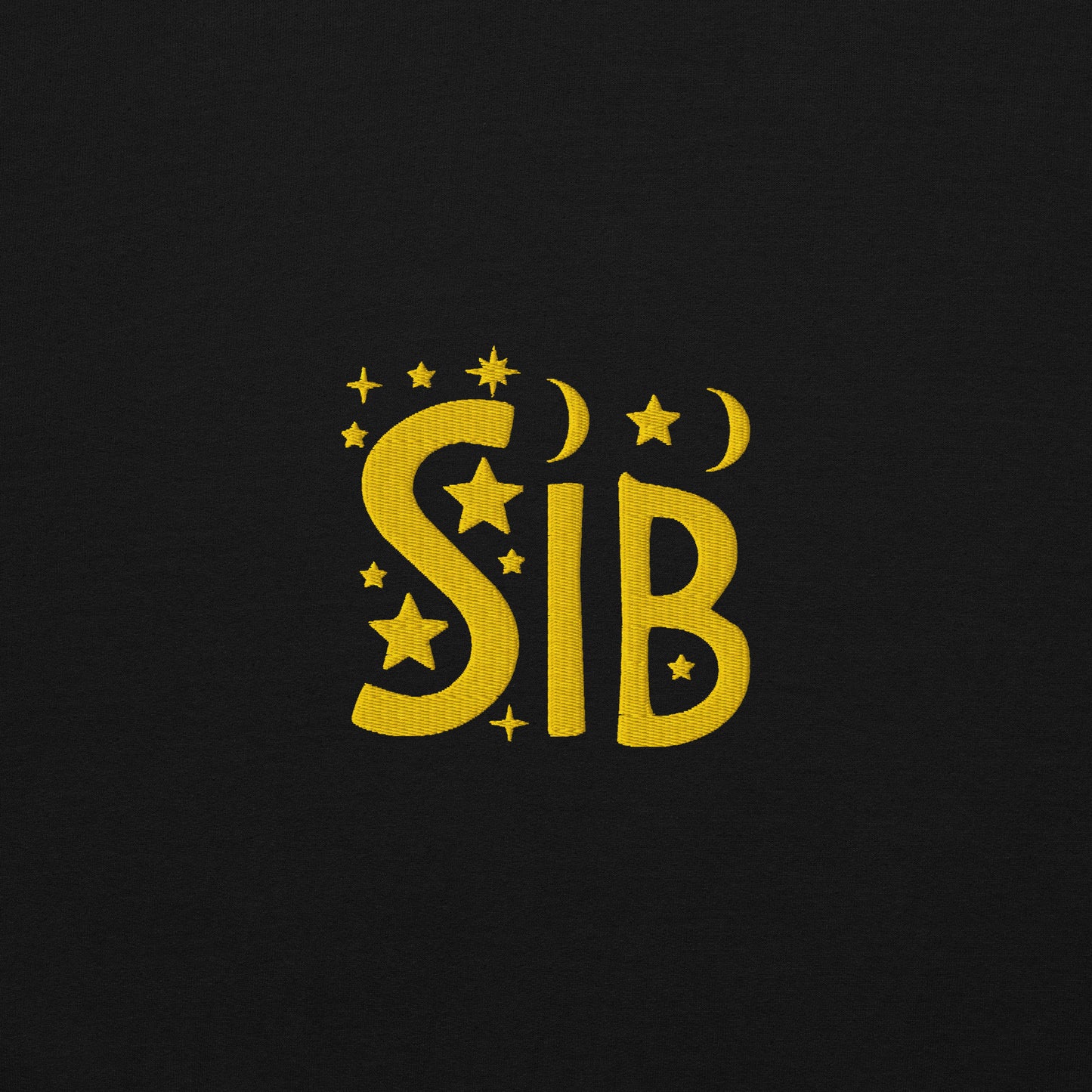 Close-up of “Sib” embroidered in gold thread on soft black cotton fabric, featuring celestial motifs like stars and moons; gender-inclusive design by Galactic Flow