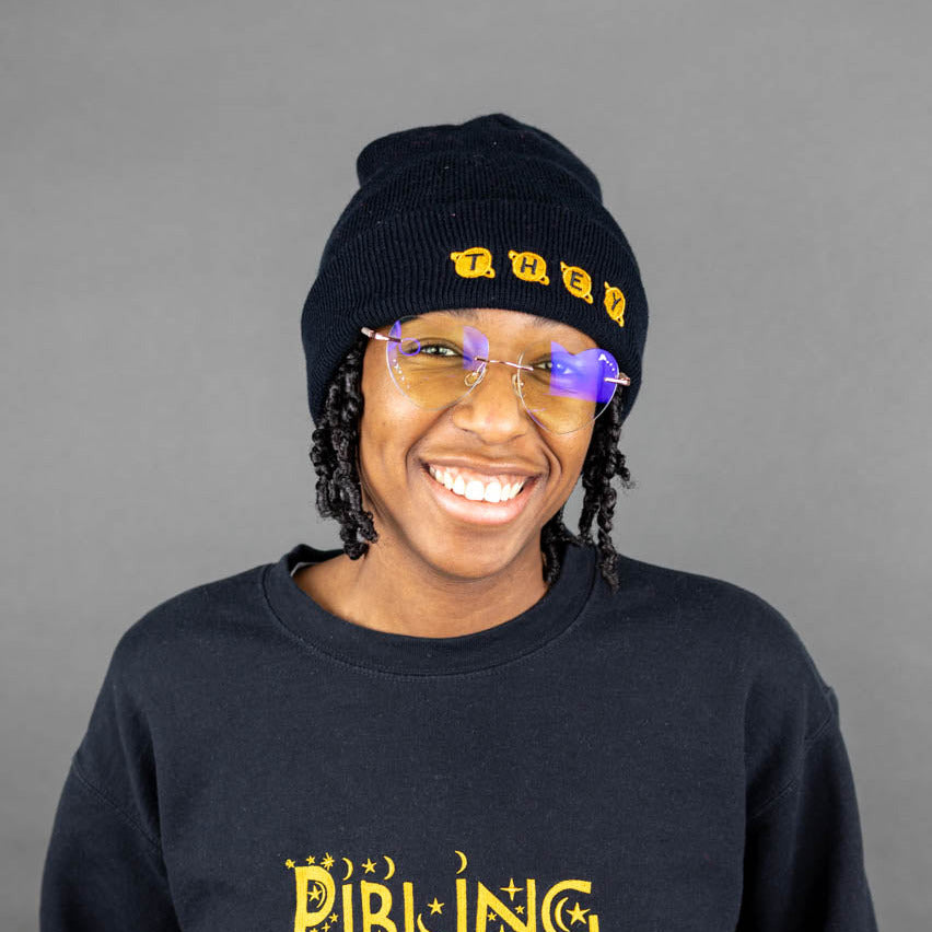 Kassidy wearing a black 'They' beanie