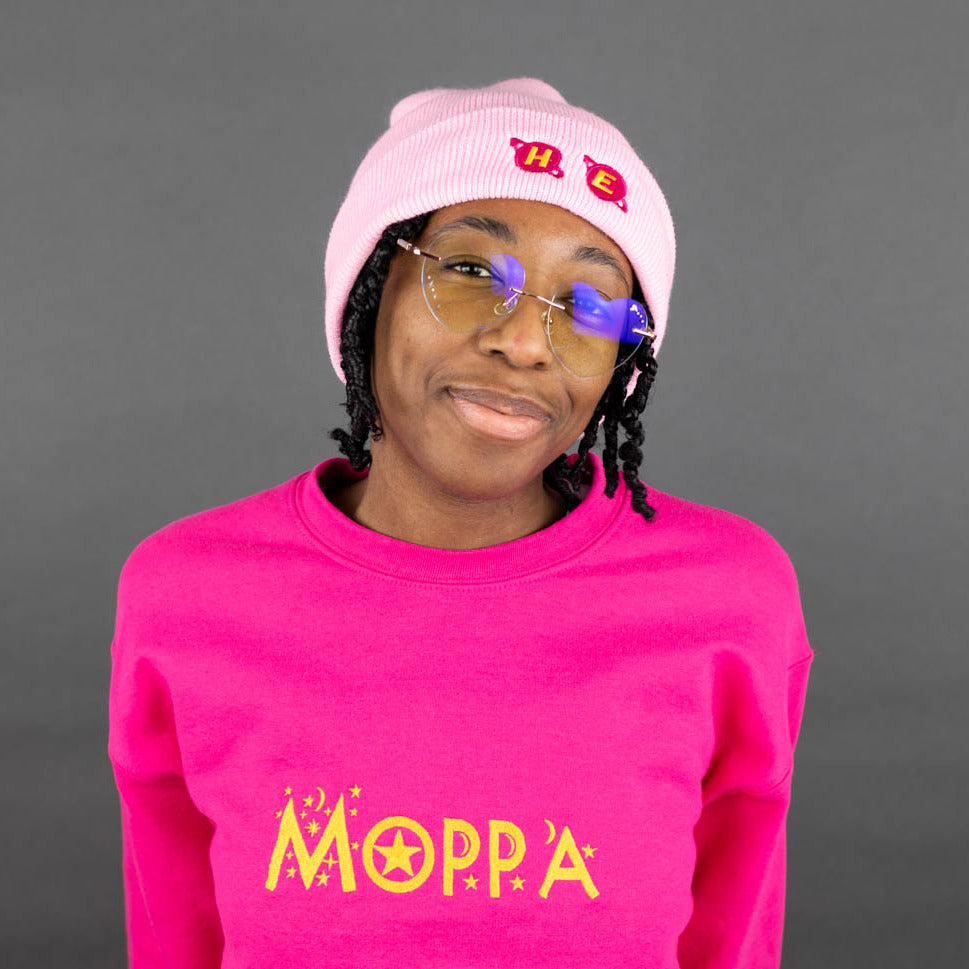 Kassidy wearing a pink 'He' beanie