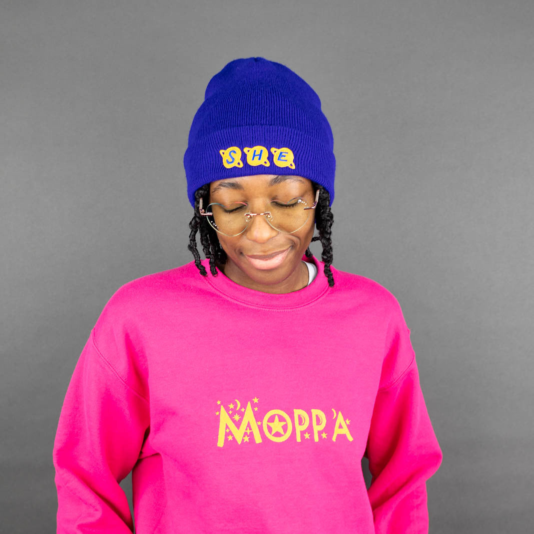 Kassidy wearing a royal blue 'she' beanie