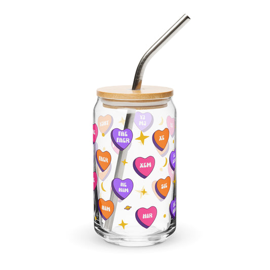 Glass tumbler with colorful heart-shaped text, wooden lid, and metal straw on a white background