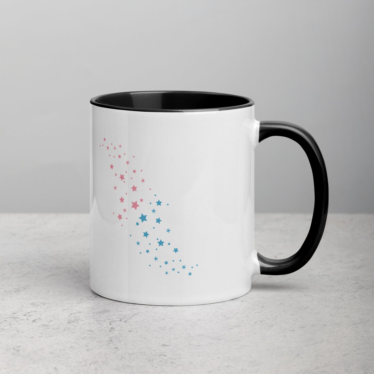 Back view of white ceramic mug with black handle and interior, featuring a celestial pattern of pink and blue stars arranged diagonally; designed by Galactic Flow for cosmic self-expression