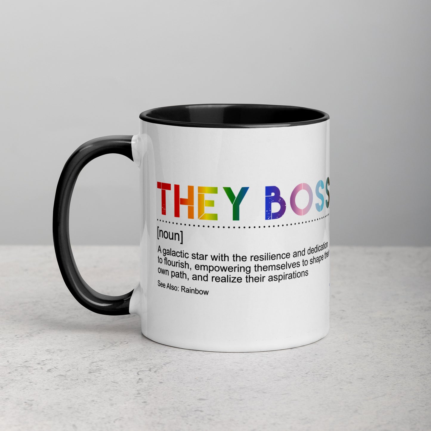 Front view of white ceramic mug with black handle and interior, featuring bold rainbow text: “THEY BOSS [noun] A galactic star with the resilience and dedication to flourish…”; designed by Galactic Flow for gender-inclusive empowerment