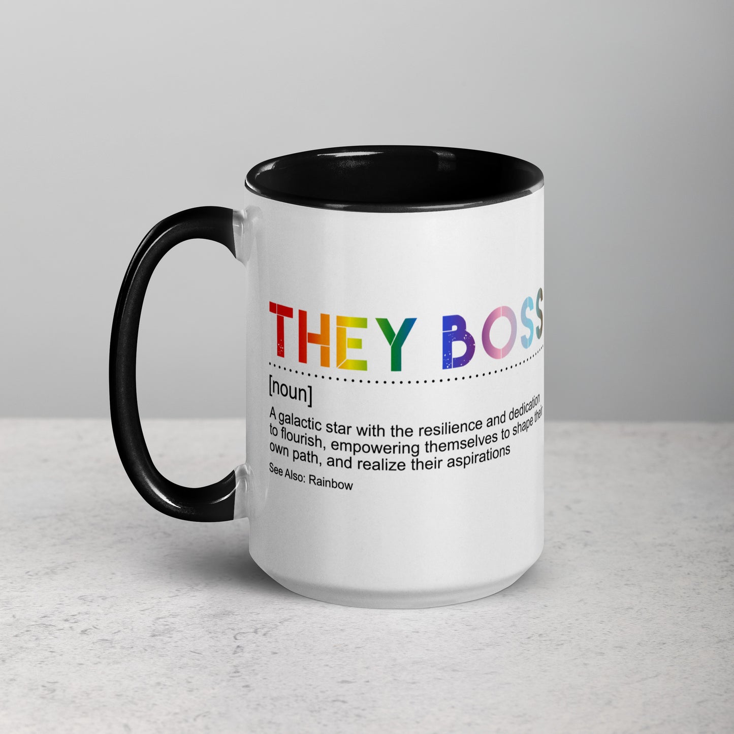 Front view of white ceramic mug with black handle and interior, featuring bold rainbow text: “THEY BOSS [noun] A galactic star with the resilience and dedication to flourish…”; designed by Galactic Flow for gender-inclusive empowerment