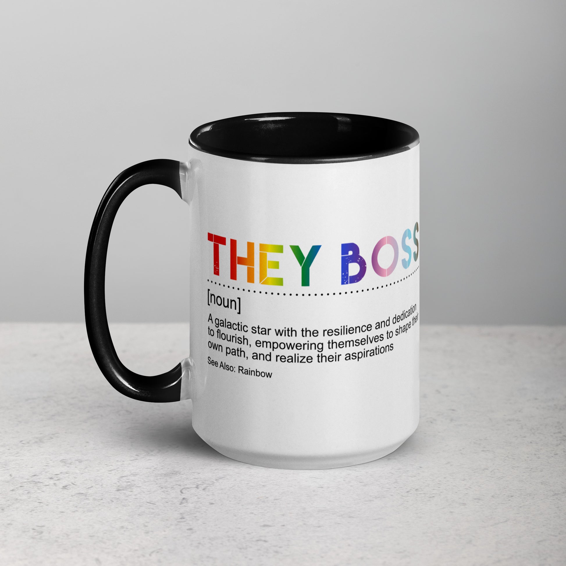 Front view of white ceramic mug with black handle and interior, featuring bold rainbow text: “THEY BOSS [noun] A galactic star with the resilience and dedication to flourish…”; designed by Galactic Flow for gender-inclusive empowerment