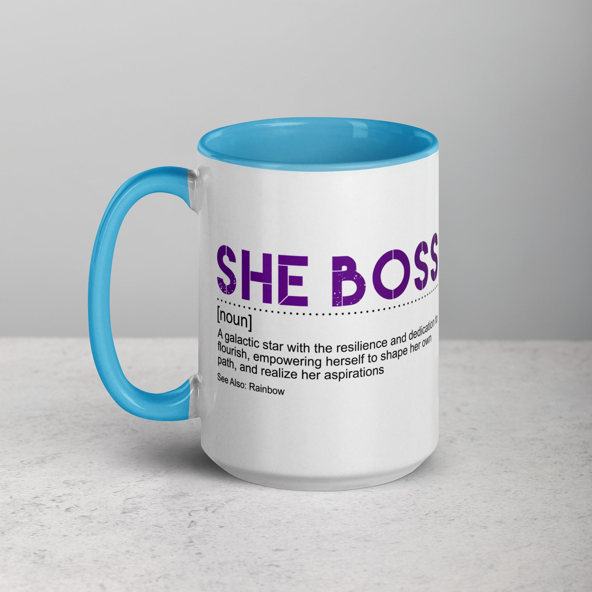 Mug with blue handle and "she boss" in purple text on a gray background